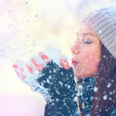 Woman blowing snow