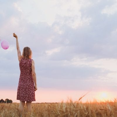 Woman letting go of balloons