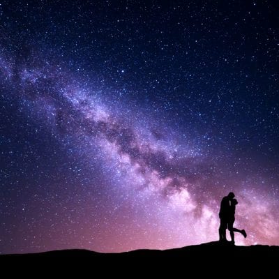 Couple kissing under night sky